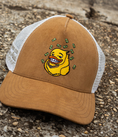 Brown and white cap with an embroidered yellow duck graphic on a textured surface